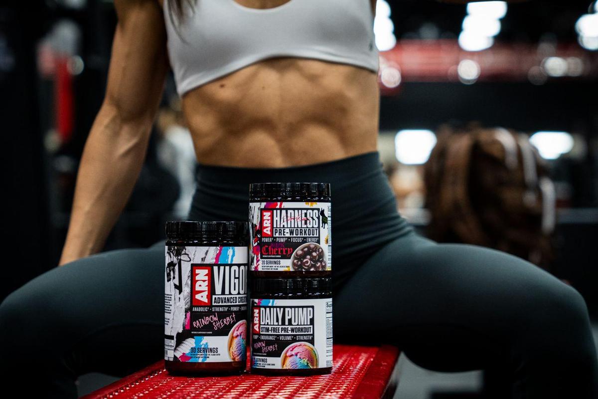 ARN supplement tubs on a gym bench in front of a seated athlete
