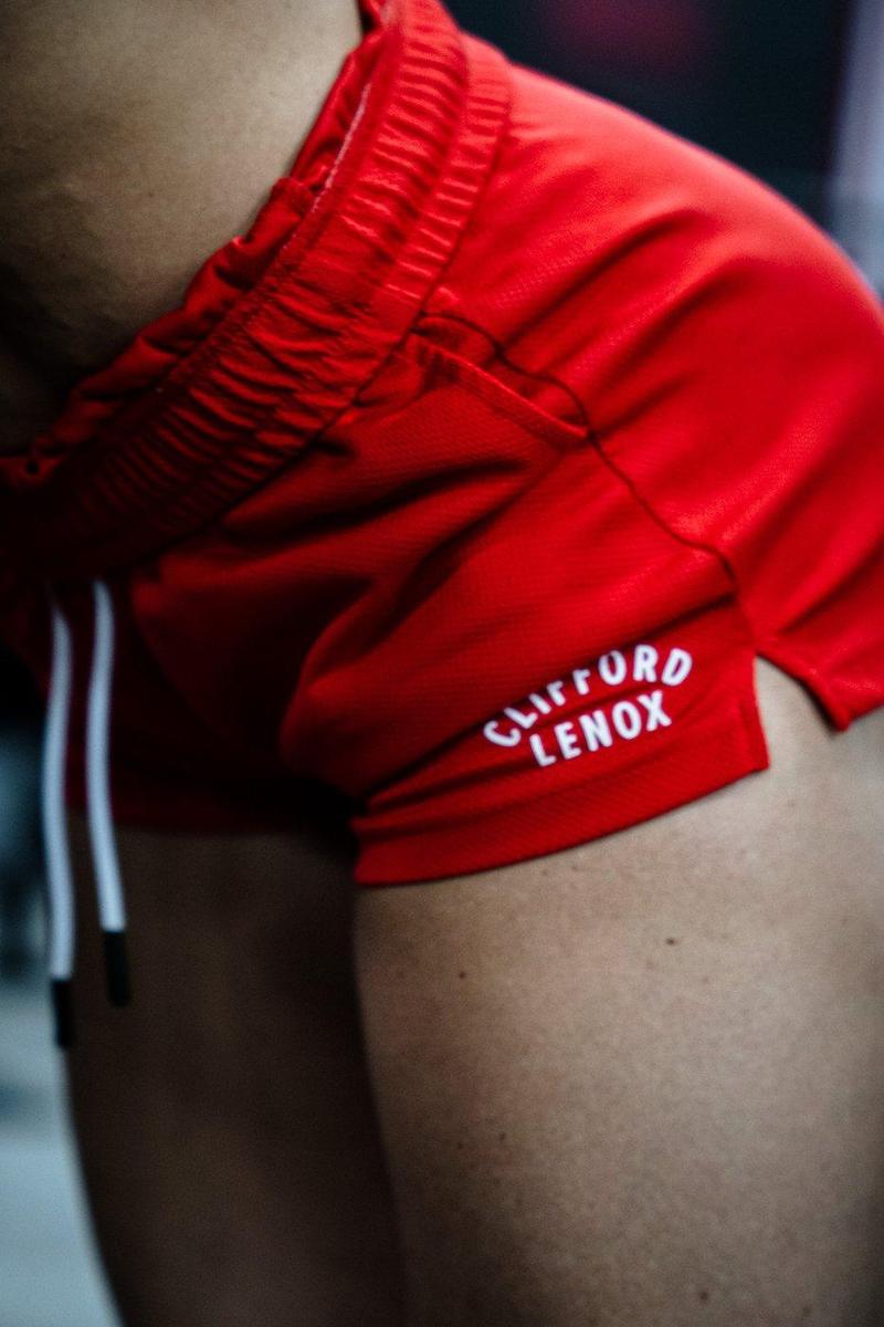 Close-up of the Clifford Lenox logo on red mesh shorts