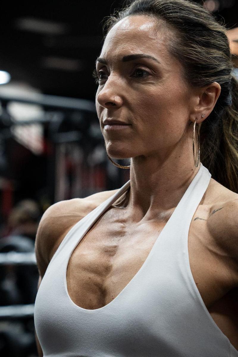Portrait of a female athlete in a white halter top in a gym