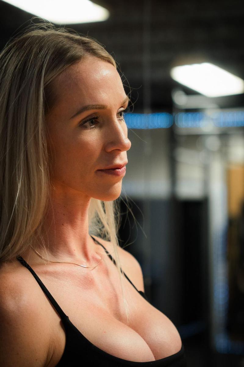Profile portrait of a blonde athlete in a dark gym